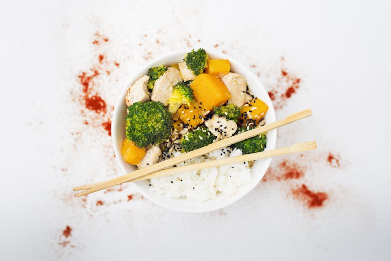A delicious Asian-inspired chicken bowl with vegetables, rice, and spices.