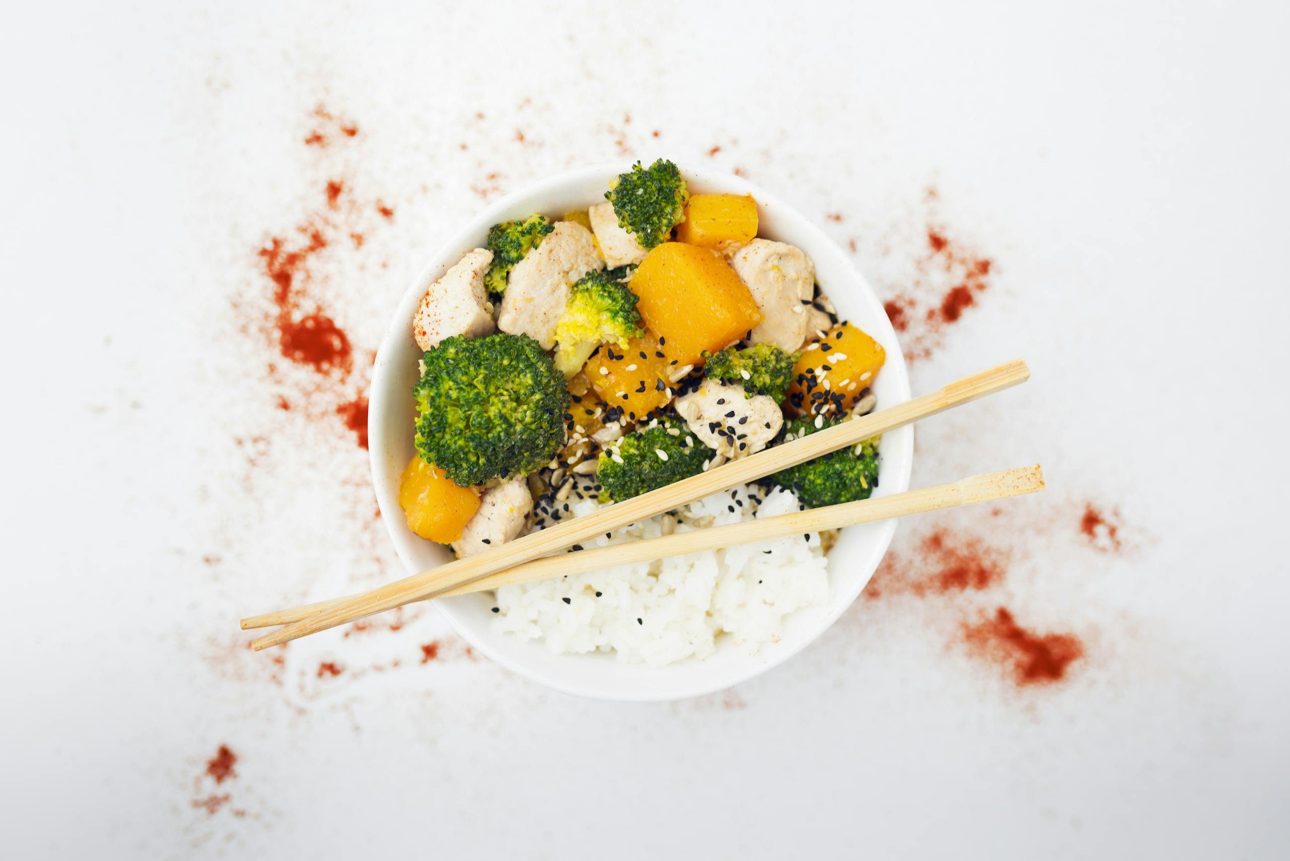 A delicious Asian-inspired chicken bowl with vegetables, rice, and spices.